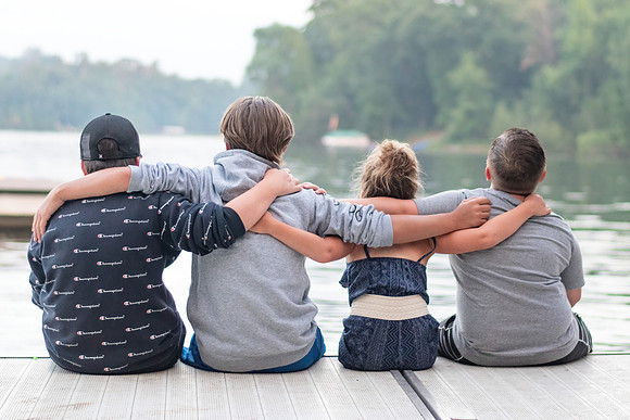 Siblings sitting on the dock at the family cabin in Emily, Minnesota - Butterfield Lake