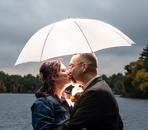 Bride and groom sharing a kiss under an umbrella in Fifty Lakes, Minnesota - Butterfield Lake