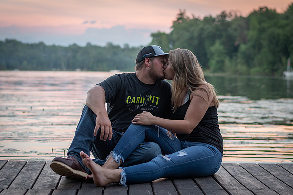 Engaged couple sharing a kiss on the dock at sunset in Fifty Lakes, Minnesota - Butterfield Lake